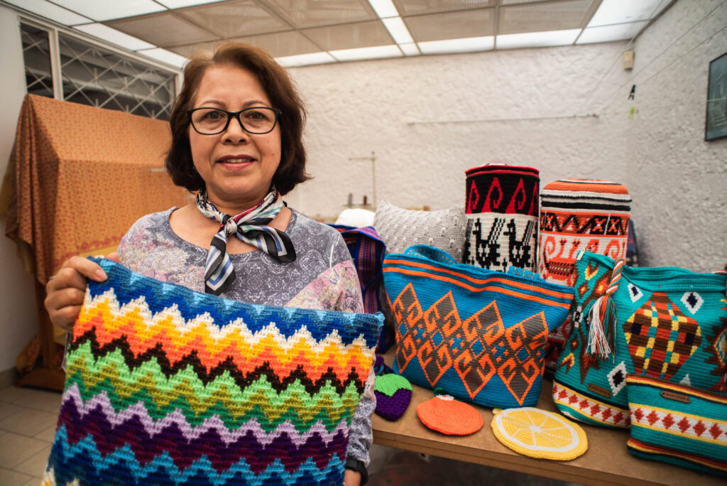 Mujer emprendedora de Colombia posando frente a sus productos